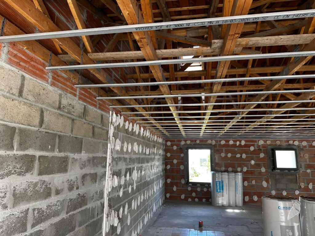 Rails métalliques Richter RSF 47 pour plafond suspendu sur charpente bois en rénovation avec isolant au sol.