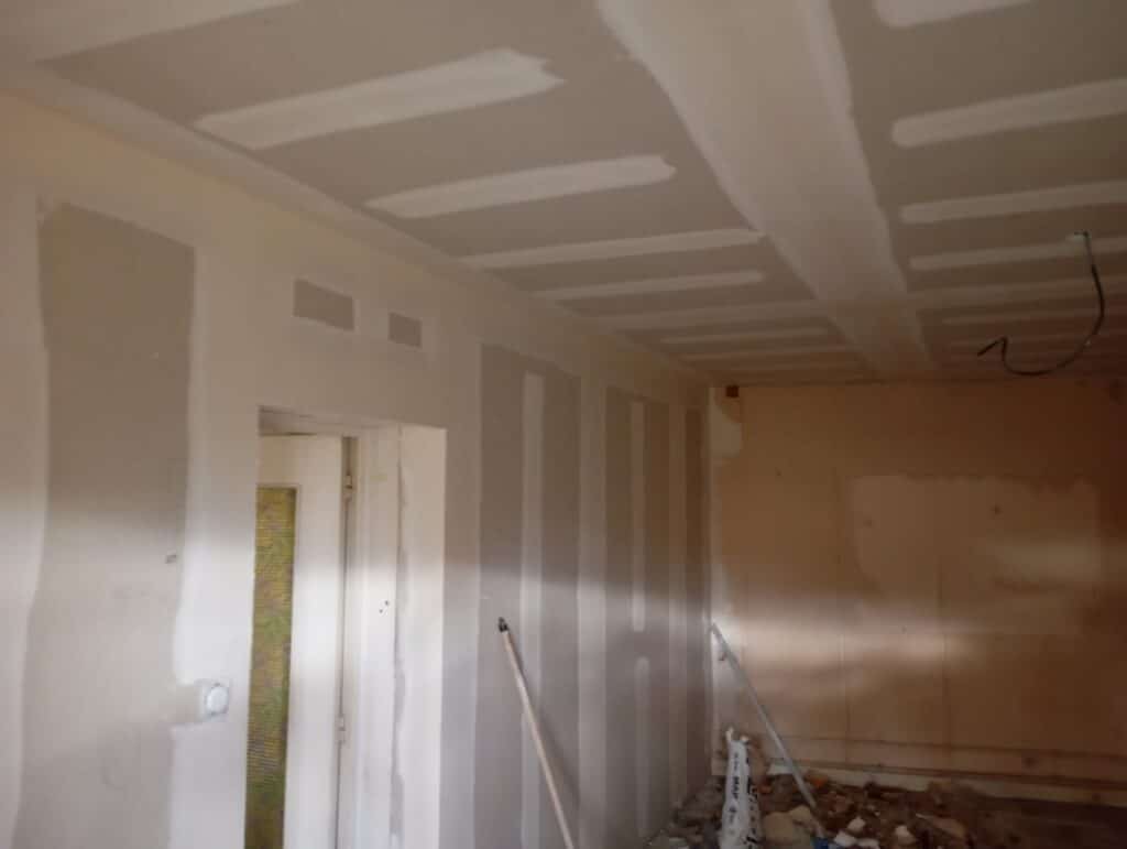 Murs et plafond en plaques de plâtre avec joints finis lors d'une rénovation intérieure.
