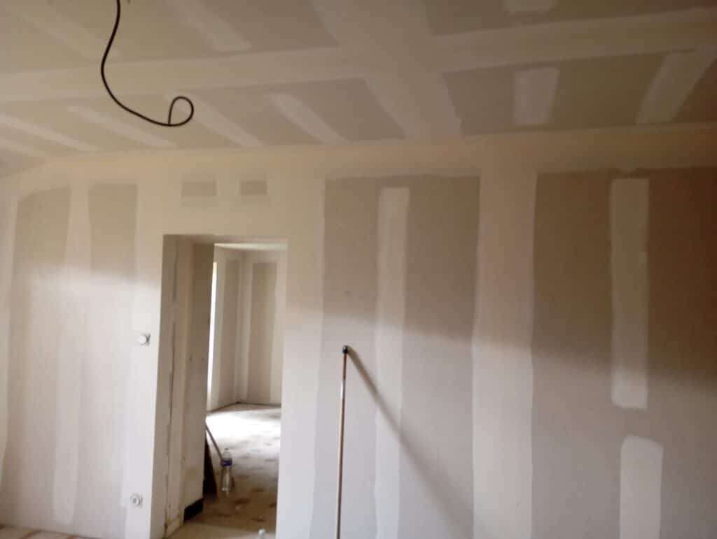 Cloisons et plafond en plaques de plâtre avec joints enduits dans une pièce en cours de rénovation intérieure.